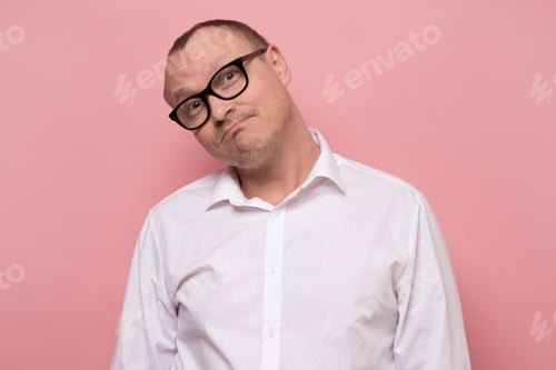 Preview: worker wearing white shirt posing in studio full of doubt and distrust.