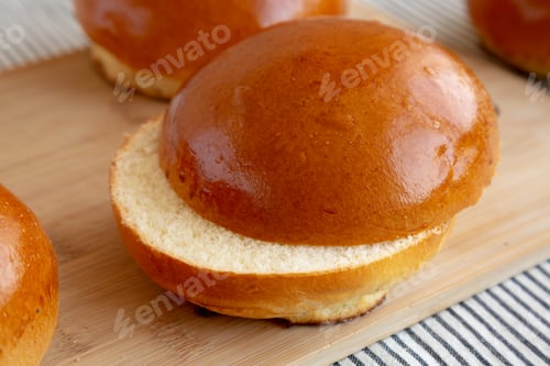 Preview: Homemade Brioche Hamburger Buns on a wooden board, side view. Close-up.