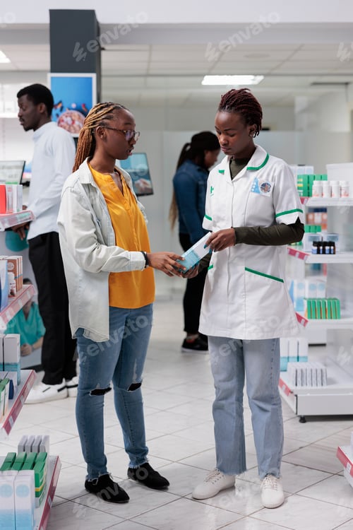 Preview: African american pharmacist helping woman choosing medications in drugstore