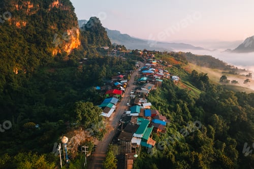 Preview: Aerial view of Morning fog and mountains with a rural village and sunrise from above