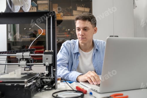 Preview: Student setting up 3D printer, using laptop