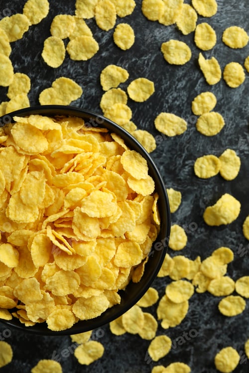 Preview: Bowl of cornflakes and sprinkled cornflakes on black smokey background