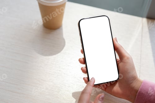 Preview: A close-up of a woman using her smartphone in a cafe in a bright day.