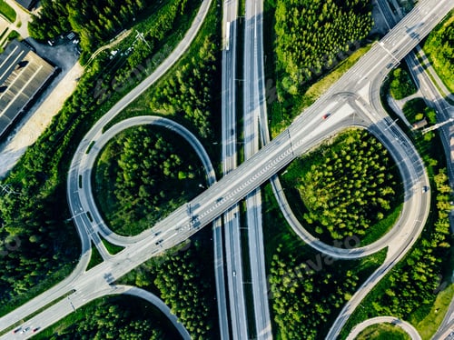 Preview: Aerial view of highway and overpass with green woods in Finland.