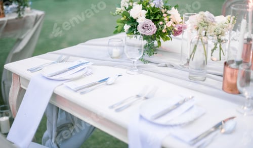 Preview: Beautiful outdoor table setting with floral decorations and candles for a wedding reception