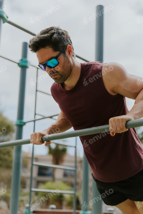Preview: Portrait of a fit man in his forties doing elevated push ups using a bar