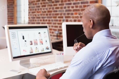 Preview: Young Businessman Looking At Computer Monitor In Office