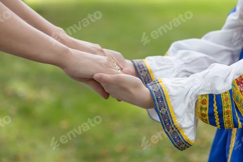 Preview: Woman's hand holding a baby hand close up. Ukrainian national clothes, Ukraine. No war