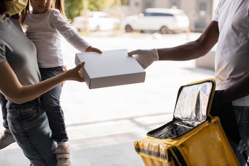 Preview: Cropped view of hands of African American courier, young female and her daughter receiving parcel