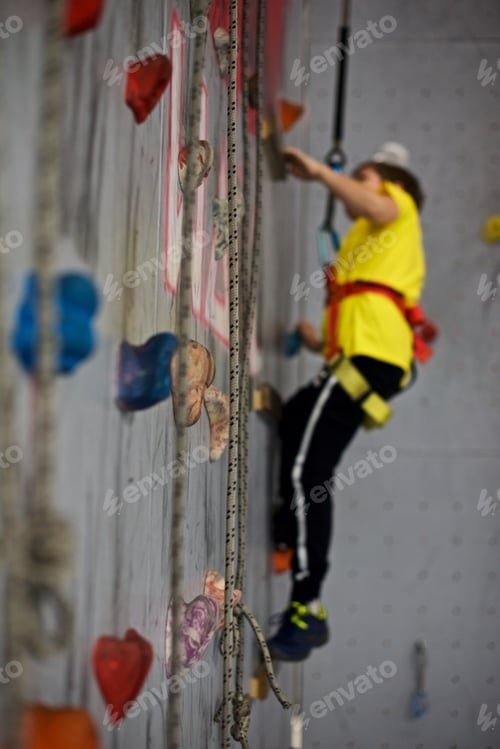 Preview: Boy Ascending Indoor Climbing Wall with Safety Gear