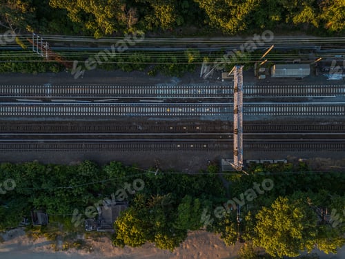 Preview: Aerial view of railway tracks through a lush green forest.