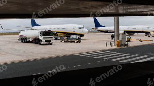 Preview: Tank truck refueling airplane on airport tarmac