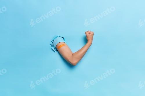 Preview: Horizontal shot of unrecognizable human keeps arms in paper hole clenches fist demonstrates power an