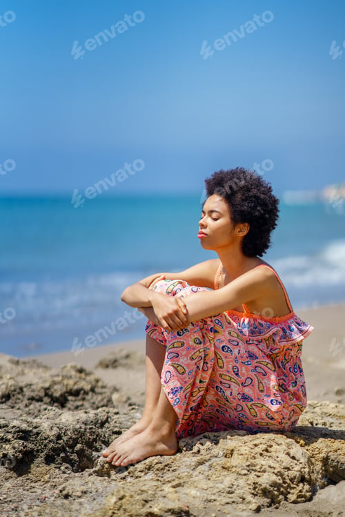 Preview: Calm black woman resting against sea
