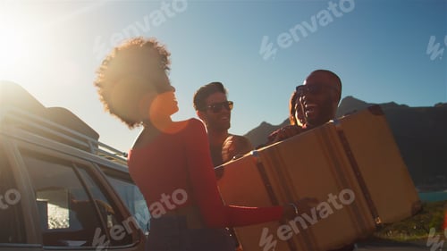 Preview: Friends Loading Luggage Onto Car Roof Rack Ready For Road Trip