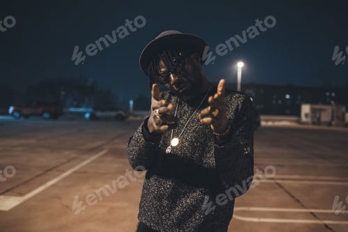 Preview: young african man standing in parking space showing hands