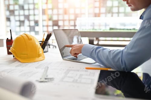 Preview: Architect man working on blueprint with engineer planing on office desk.