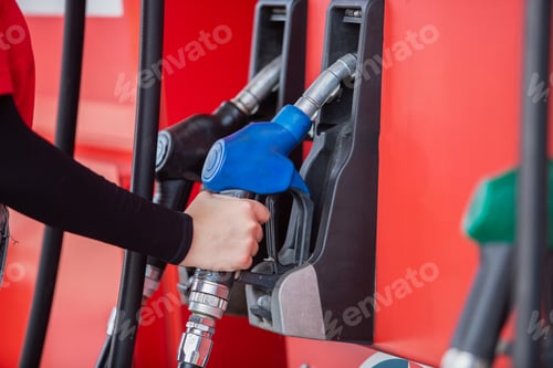 Preview: close up hand of woman holding pump nozzle for service at gas station