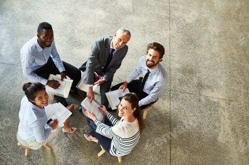 Preview: High angle portrait of a group of coworkers looking up while sitting around in a circle