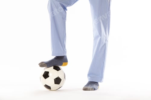 Preview: Young man in pajama playing football. Legs. Night wear