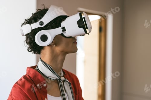 Preview: Using VR headset, young man exploring virtual reality experience at home