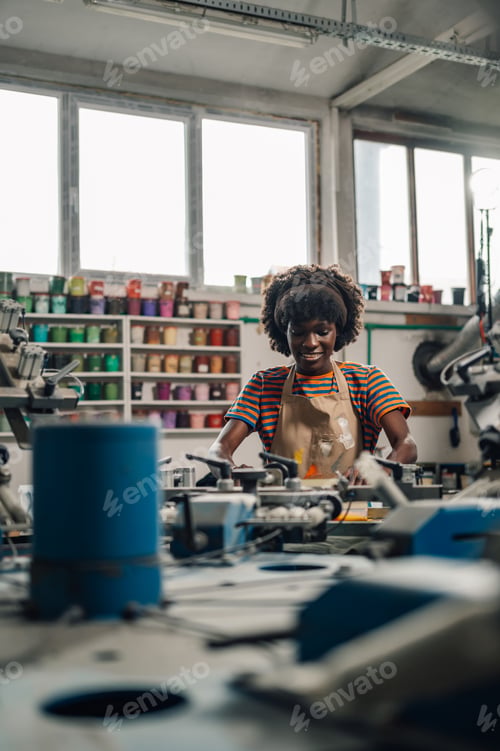 Preview: Interracial printing worker is silkscreen printing at printing workshop