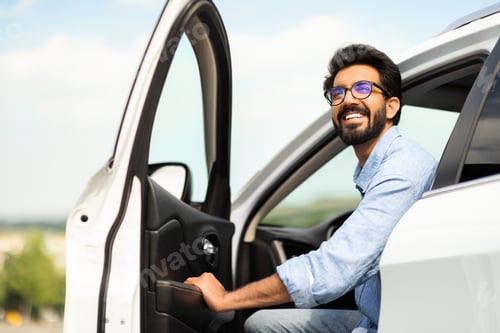 Preview: Happy eastern man going out the car, low angle photo