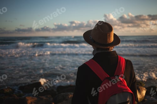 Preview: Gentle breeze accompanies man's seaside stroll at dusk.