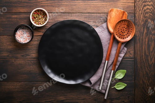 Preview: Cooking wooden utensils, black empty plate, basil leaves and spices on old wooden background.