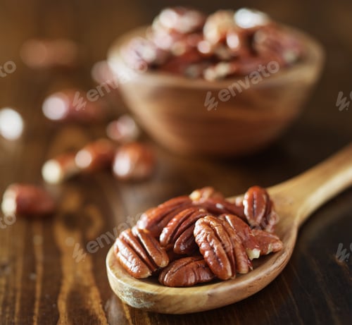 Preview: pile of pecans on wooden table shot close up