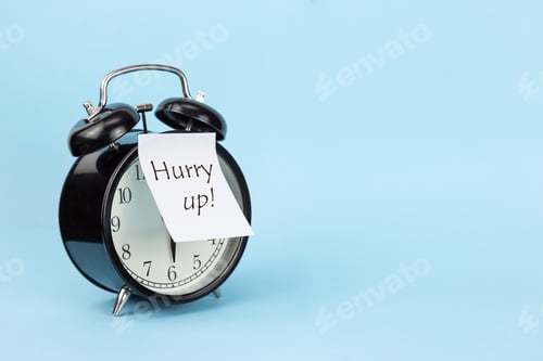 Preview: round black classic alarm clock with hurry up sticker on blue background