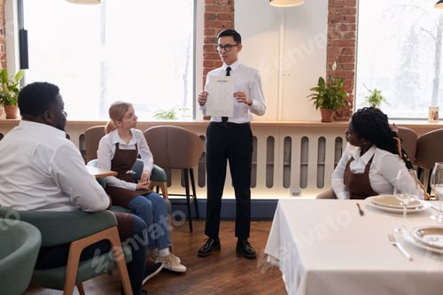 Preview: Restaurant Manager Showing New Menu To Staff