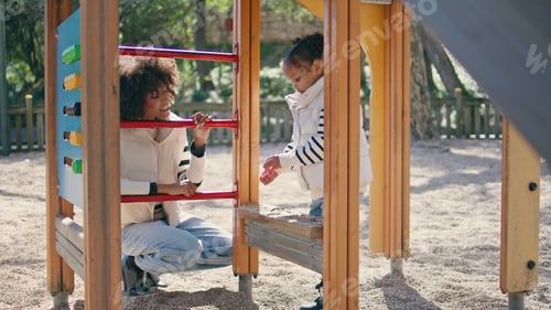 Preview: Mother child playing playground sunny weekend. African woman looking girl game