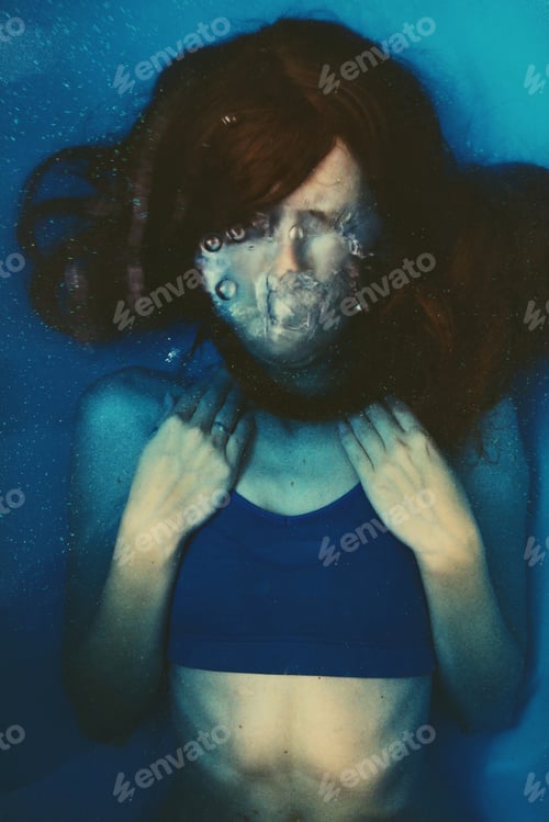Preview: Young woman under blue water