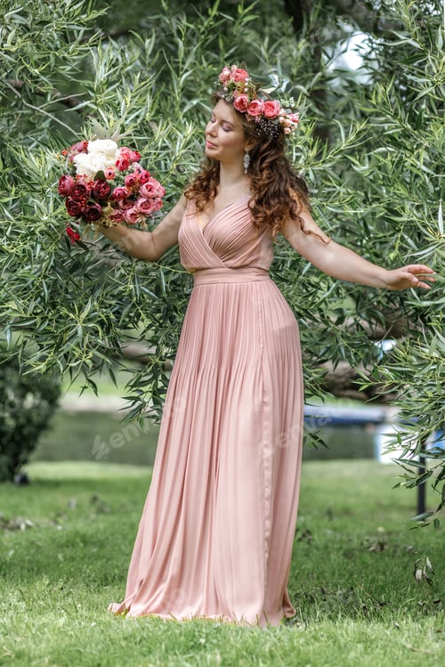 Preview: Young girl in a pink dress. Beautiful medieval elven princess with flowers in her hair in the forest