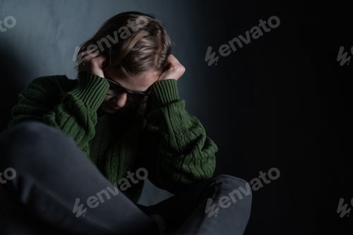 Preview: Sad little girl, alone in darkness, sitting and and covering face