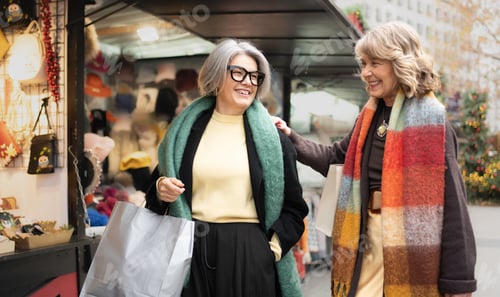 Preview: Senior women friends shopping at christmas market event