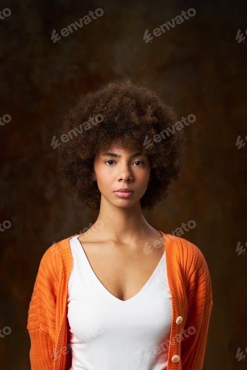 Preview: portrait of a latina woman with afro hair, expressing strength and determination with a look of