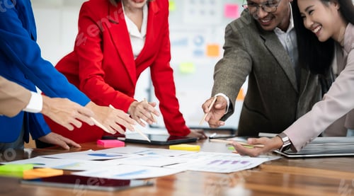 Preview: Group of young confident business people analyzing data while spending time in the office