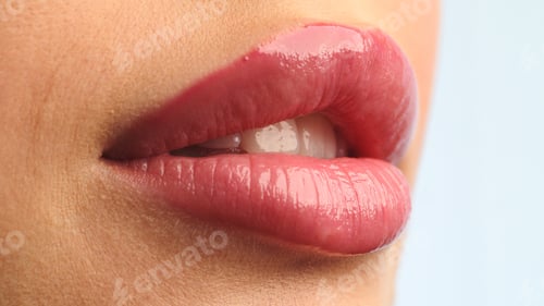 Preview: Closeup shot stylist applies lipstick to the lips of the female model. Woman making make up.