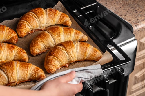 Preview: Baked croissants on oven tray, fresh homemade pastry taken from oven