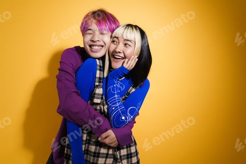 Preview: Asian couple with multicolored hair hugging and laughing together