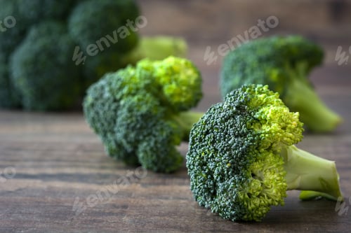 Preview: Fresh green broccoli florets resting on rustic wooden table