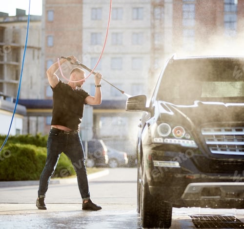 Preview: Sporty man washing his black car outdoors