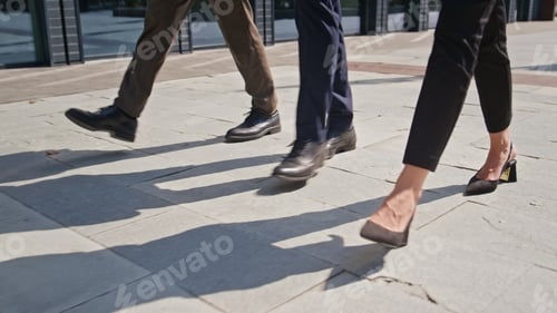 Preview: Three pairs legs walking pavement sunny day closeup. Feet people stepping street