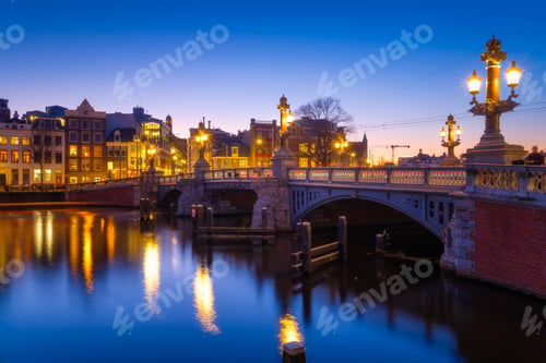Preview: Blue bridge, Amsterdam, Netherlands. Blauwbrug. Evening cityscape. Blue sky and city lights.