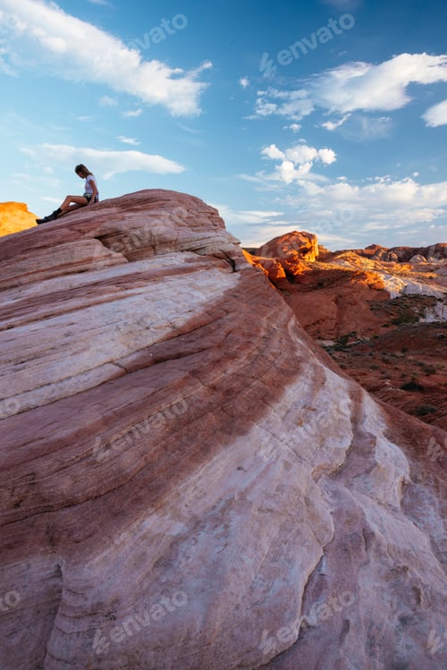 Preview: Explorer taking in the majestic view atop a beautiful desert formation at sunset