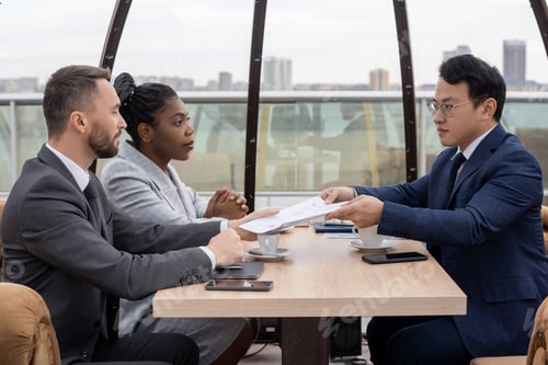 Preview: Young confident Asian economist passing papers to one of coworkers
