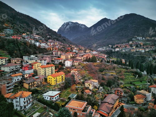 Preview: Drone view of Lake Como surrounded by a town and mountains in the evening in Italy