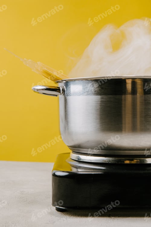 Preview: close-up shot of delicious spaghetti boiling in stewpot on yellow